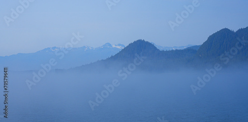 View of snow capped mountains appearing above a sea of clouds in the Inside Passage of Southeastern Alaska in the Pacific Ocean, USA photo