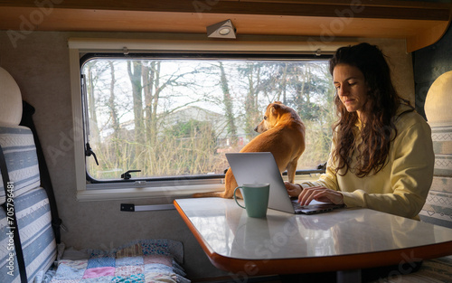 Quadro su tela Woman teleworking while traveling in a motorhome with the computer and in the co