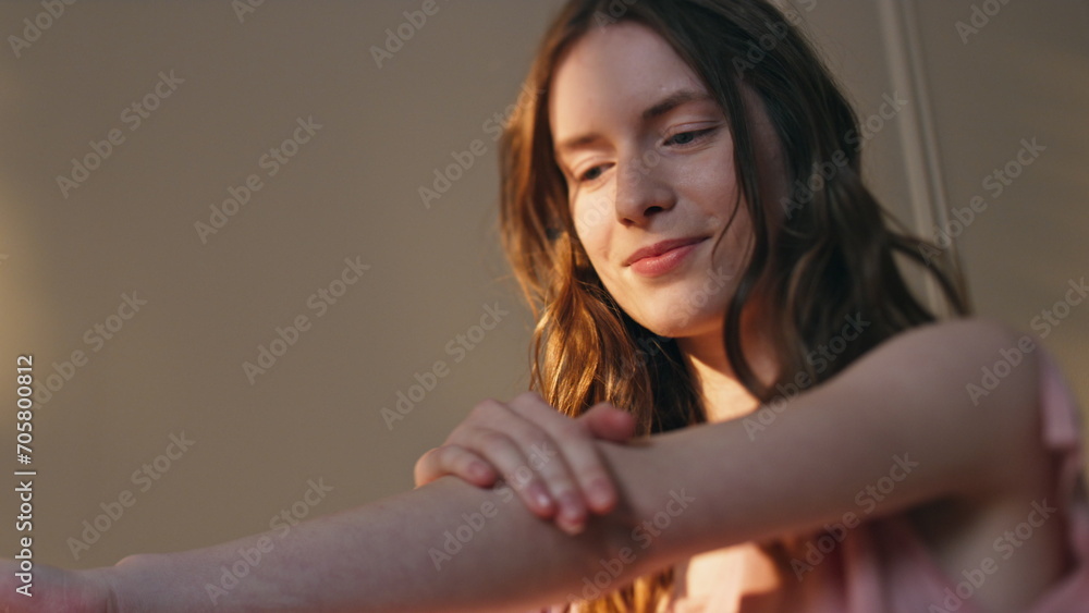 Closeup girl applying lotion on smooth skin in sunlight. Serene woman enjoying Closeup girl applying lotion on smooth skin in sunlight. Serene woman enjoying