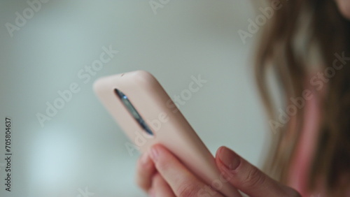 Closeup hands holding smartphone in dark room. Worried girl looking screen read