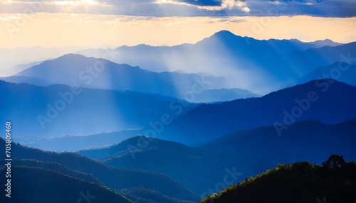beautiful landscape of blue mountains layers during sunset with sunrays