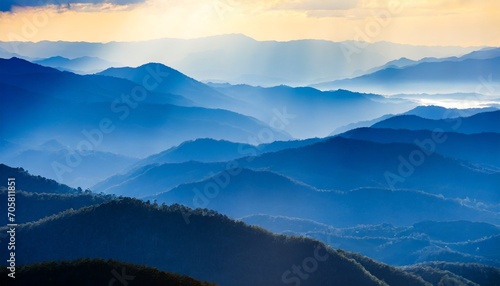 beautiful landscape of blue mountains layers during sunset with sunrays photo