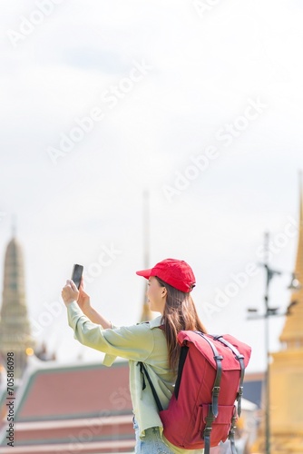 Photography Young asian woman traveler with phone capturing moments and exploring Wat Phra K