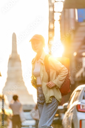 Asian Woman Traveler Posing Against the Sunset Moment of Wat Arun - The Temple of Dawn in Bangkok Riverside, Thailand