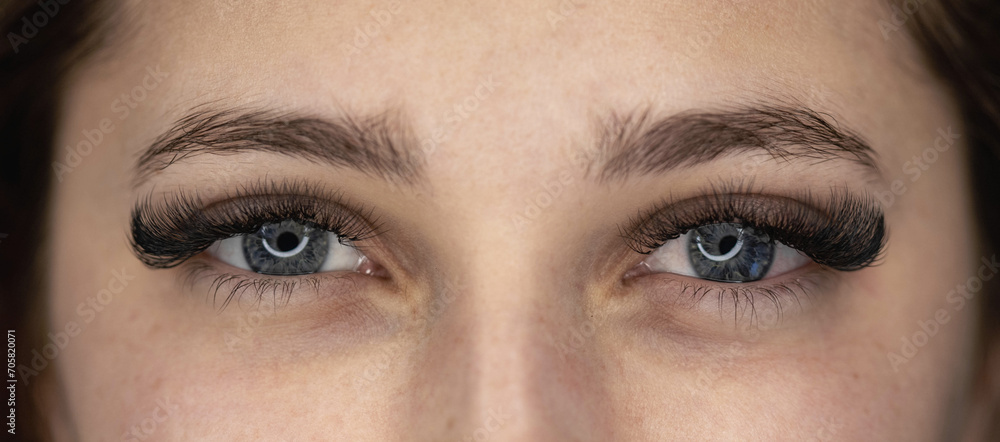 Fototapeta premium Woman making eylash extensions for a girl.