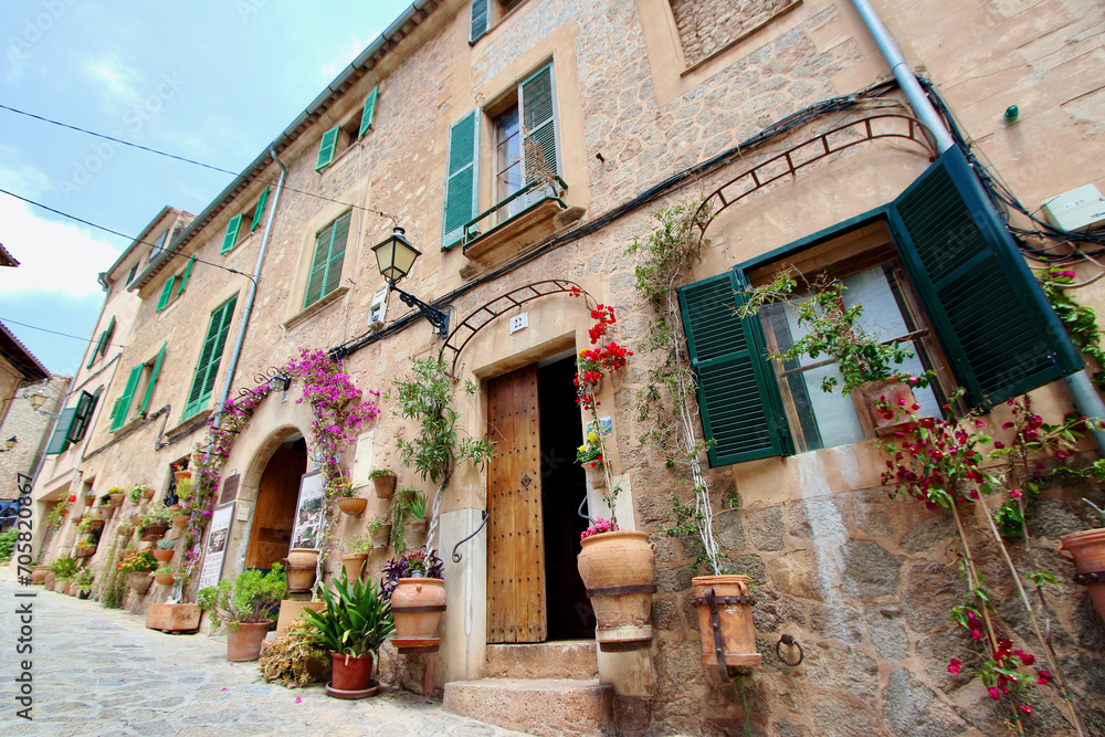 View of idyllic Valldemosa village old houses decorated with seasonal plants and flowers, Mallorca, Balearic Islands, Spain (no property release added as shop names and property have been deleted)