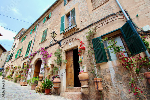 View of idyllic Valldemosa village old houses decorated with seasonal plants and flowers  Mallorca  Balearic Islands  Spain  no property release added as shop names and property have been deleted 