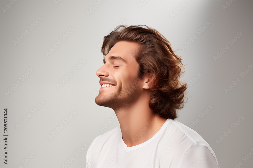 Handsome Caucasian Man contented expression and healthy wavy hair against white background Handsome Caucasian Man contented expression and healthy wavy hair against white background