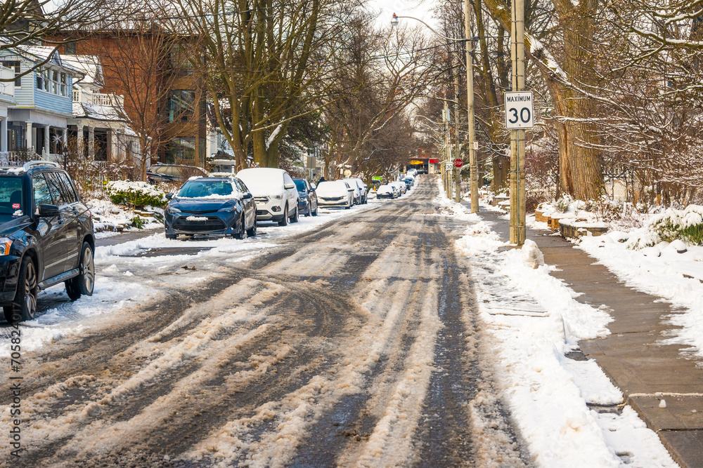 Snow on an older tree lined residential street with parked cars shot in the toronto beaches neighbourhood Snow on an older tree lined residential street with parked cars shot in the toronto beaches neighbourhood