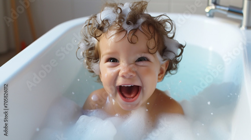 little happy child playing with foam in a bubble bath