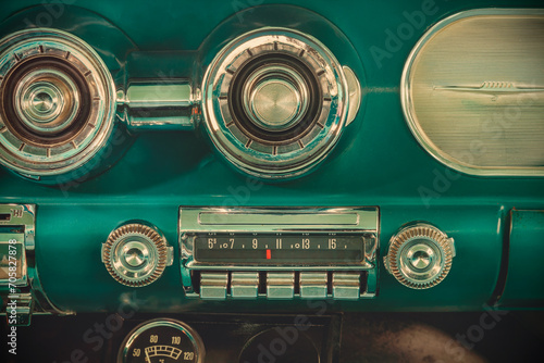 Retro styled image of an old car radio inside a green classic American car © Martin Bergsma
