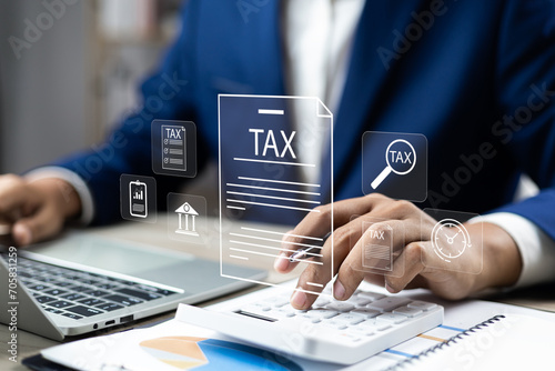 Tax and Vat concept. Government, state taxes concept. Businesman using calculator and laptop to complete Individual income tax return form online for tax payment. Data analysis, financial research. photo