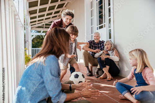 Multi-generational family playing soccer together on the porch photo