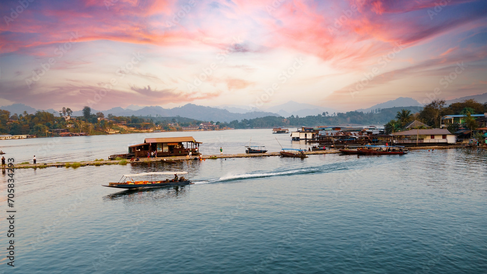 Kanchanaburi Province,Thailand - 13th December 2023: Floating house and long tail boat in river with sunset view at Sangkhlaburi, Kanchanaburi Province,Thailand.