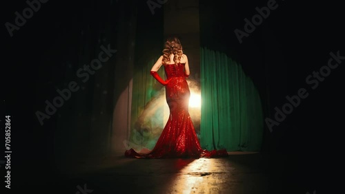 portrait back rear view Sexy beauty woman stands on stage concert hall singer performing song holding retro microphone in hands. happy girl sings in dark karaoke bar clud makeup red lips dress. art 4k photo