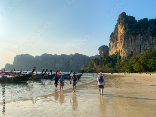 Tourists leaving Railay Beach, Thailand at sunset via water taxis. 