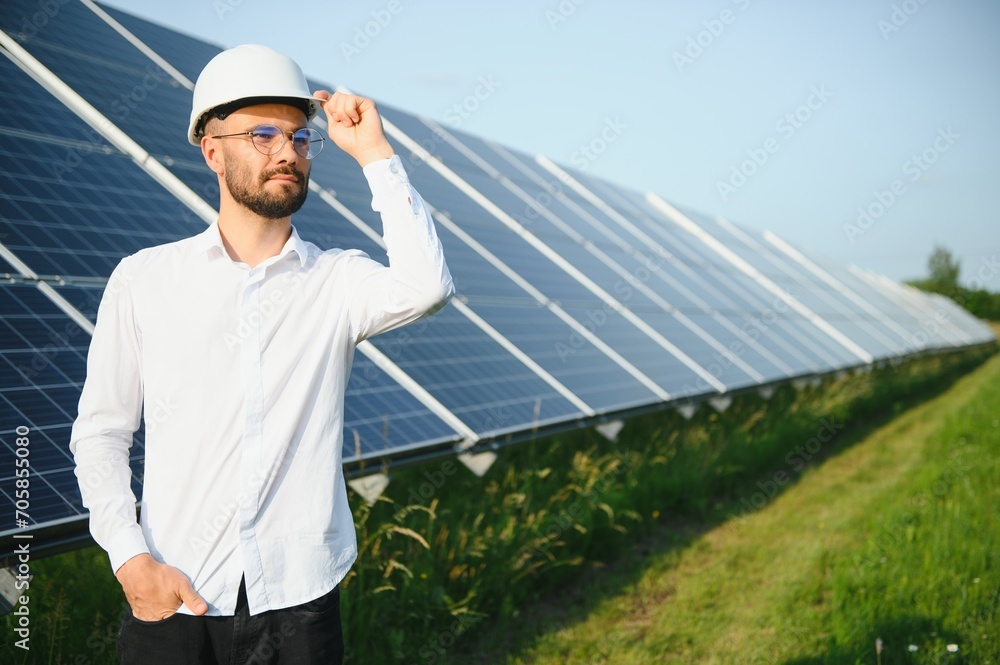 Solar power plant. Man standing near solar panels. Renewable energy.