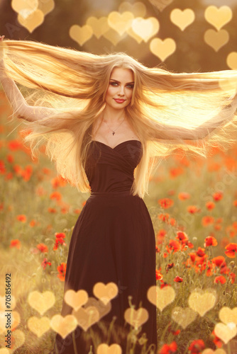 Beautiful brunette woman in a black dress with a bouquet of flowers in a poppy field © olenakucher