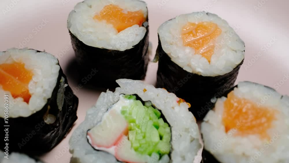 California roll sushi on a 360 degree rotating table on a black background 
