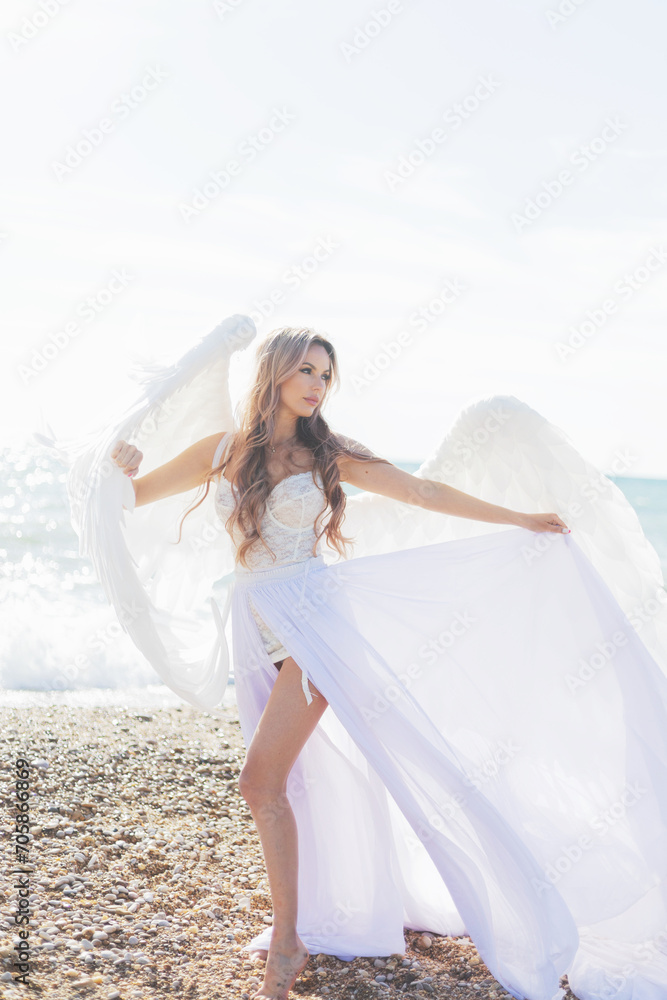 beautiful girl with angel wings is walking along the seashore beautiful girl with angel wings is walking along the seashore