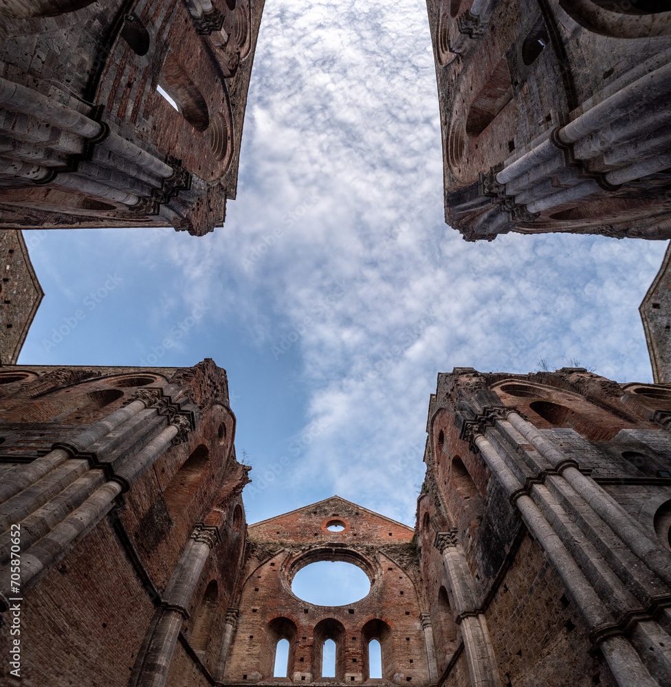 Fototapeta premium Missing ceiling opening the view to the sky in the destroyed abandoned Cistercian monastery San Galgano in the Tuscany