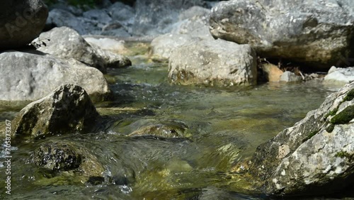 Clean water runs between rocks of a mountain stream