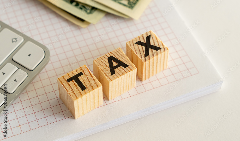 Tax text in wooden cubes and tax or vat form documents to complete Individual tax return