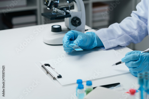 Scientist wearing medical gloves nanotechnology  research  fiber  microbiology  glass  test tube  medicine  healthcare  pharmaceutical manufacturing  laboratory  science  chemistry  genetics  genes.
