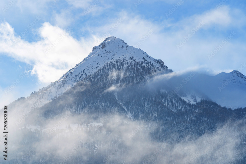 Mountain covered with snow and fog. Alpine landscape in Italy, Europe. Snow-capped mountains
