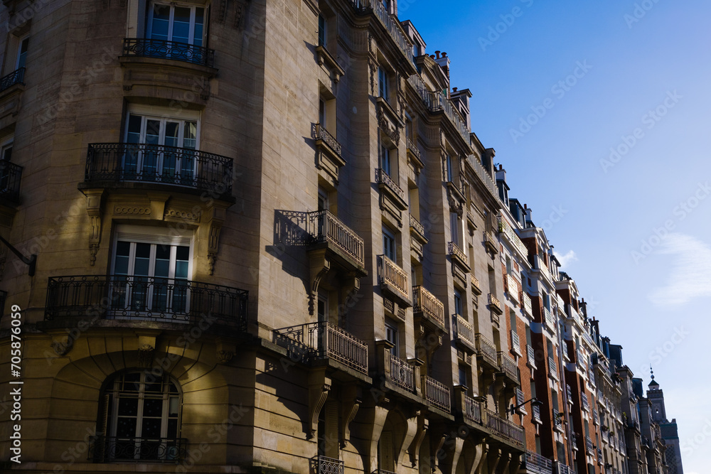 Facade illuminated by the golden afternoon sun of neoclassical buildings on the streets of Paris.