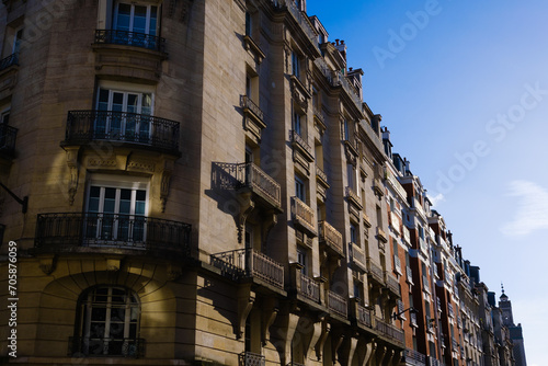 Facade illuminated by the golden afternoon sun of neoclassical buildings on the streets of Paris.