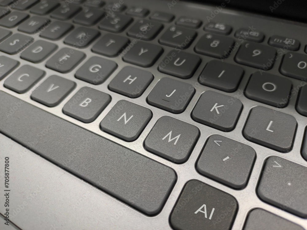 Grey laptop keyboard with AI (artificial intelligence) key closeup Grey laptop keyboard with AI (artificial intelligence) key closeup