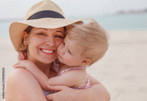 Portrait of mother holding her bay girl at beach