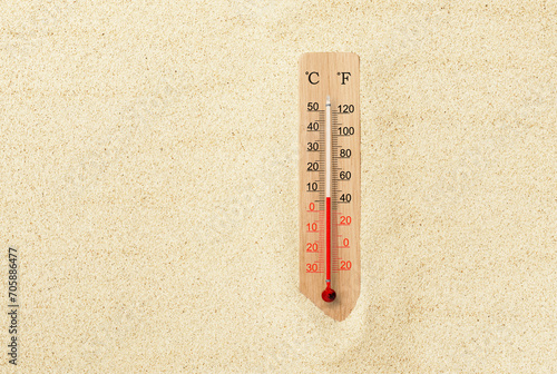 Hot summer day. Celsius and fahrenheit scale thermometer in the sand. Ambient temperature plus 7 degrees