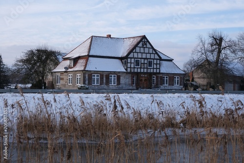 Landscape with Motlawa river and traditional building on bank of river, Ledowo, Zulawy Gdansk, Poland