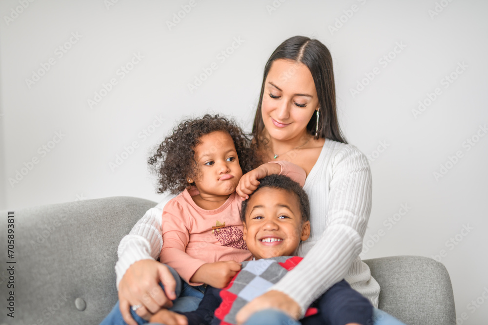 family with boy and girl child posing on photo shooting, sitting on couch