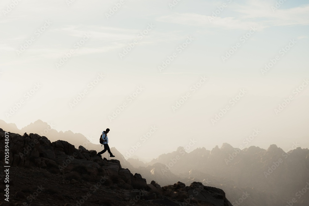 silhouette of a person on the top of the mountain