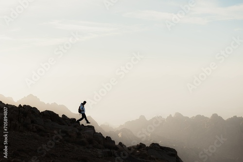 silhouette of a person on the top of the mountain