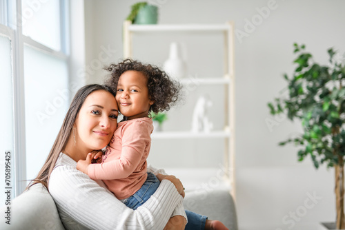 Mother with little daughter at home sofa © Louis-Photo