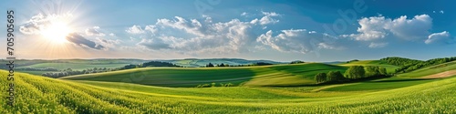 Sunrise over rolling green hills with vibrant sky. Landscape panorama photography. New beginnings concept. Design for banner, wallpaper, header. Panoramic shot with copy space