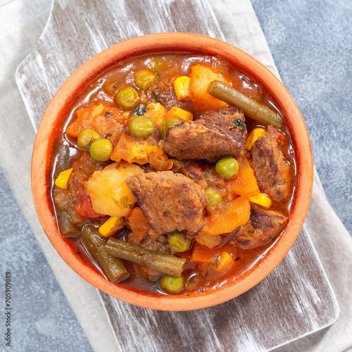 Delicious beef stew with potato, green beans, carrot, peas and corn, top view, square format