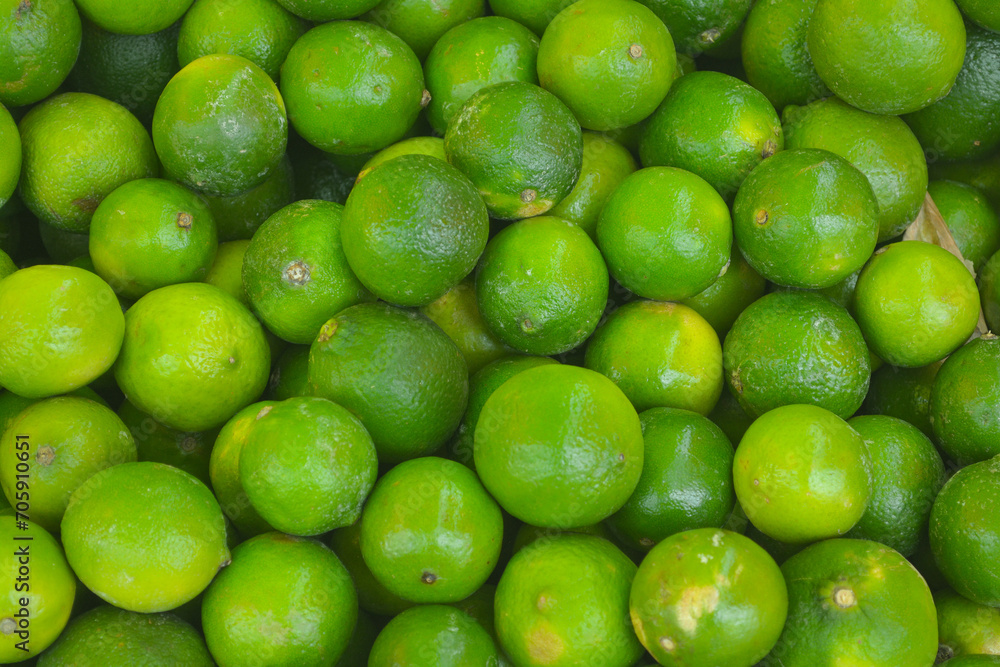 Fresh green ripe lime fruits on retail market stall display, close up view. Fresh green ripe lime fruits on retail market stall display, close up view.