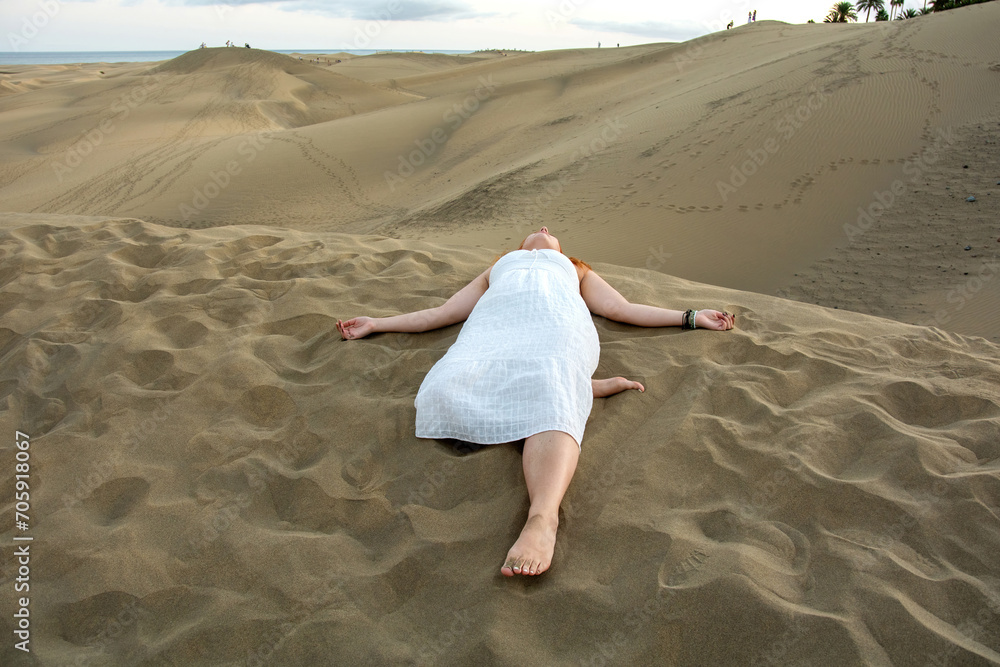 Young woman lies in the sand