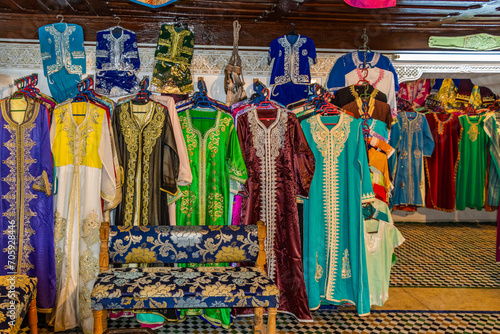 Morocco, row of typical colourful womens embroidered djellaba tunics for sale.