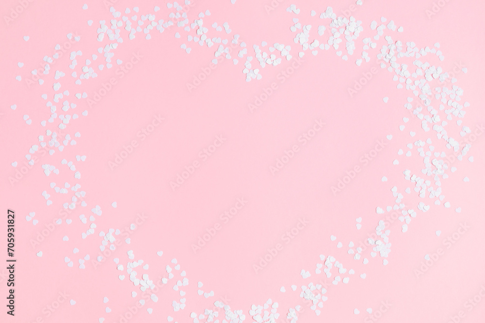 Valentine's Day concept. White confetti hearts on a pastel pink background. Love concept. Frame of hearts. Sample.