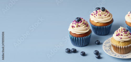 horizontal banner, classic blueberry cupcake on a blue background, homemade cakes, sweet dessert, place for text