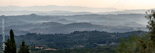 Typical Tuscan landscape with hills and cypresses in the very early morning near Montaione photo