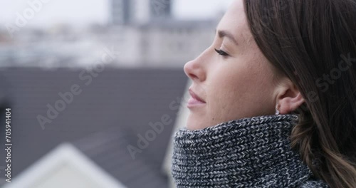 Woman, balcony and thinking in outdoor, city and relaxing or resting on rooftop at home. Female person, peace and calm on apartment terrace or traveling on vacation, holiday and winter getaway photo