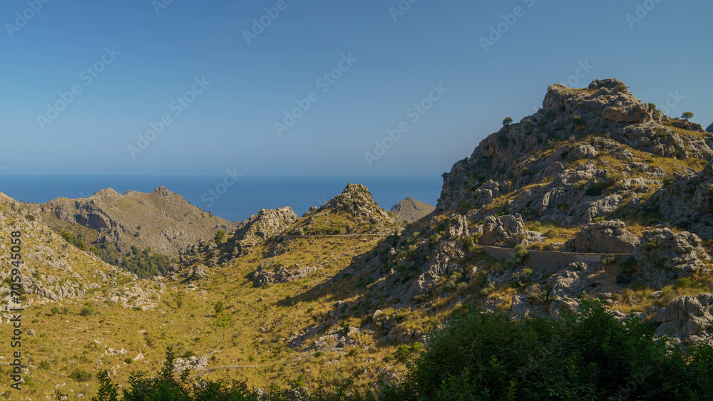 Fototapeta premium Die Straße nach Sa Calobra auf Mallorca schlängelt sich durch die Berglandschaft der Tramuntana und bietet atemberaubende Ausblicke.
