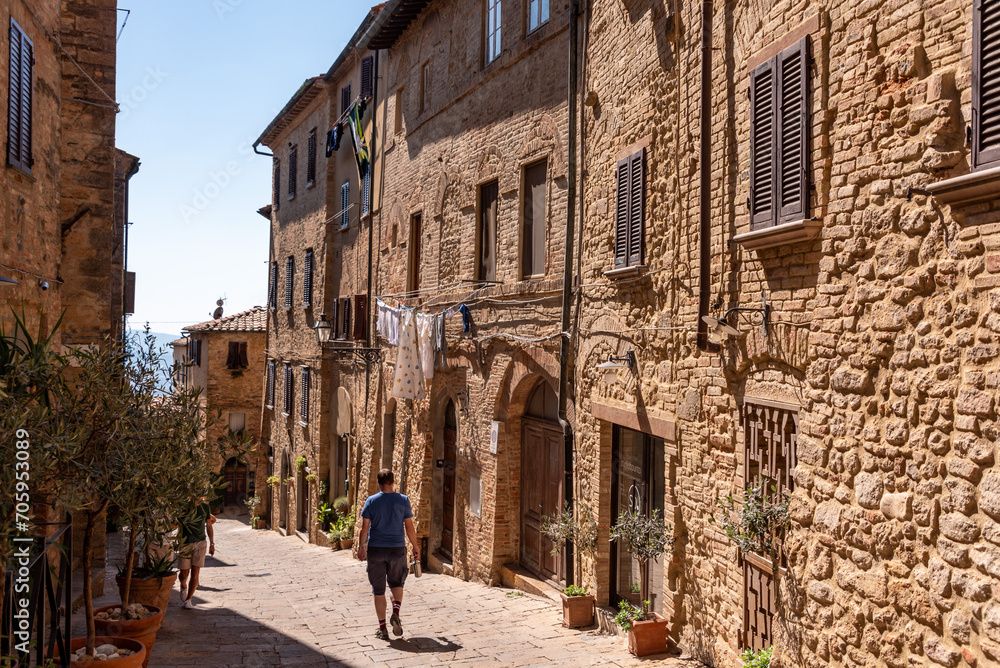 A person walking on a scenic alley in downtown Volterra